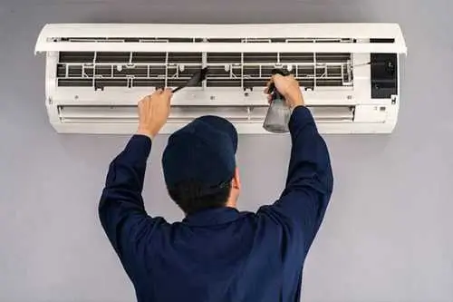 Technician diagnosing split AC electrical layout